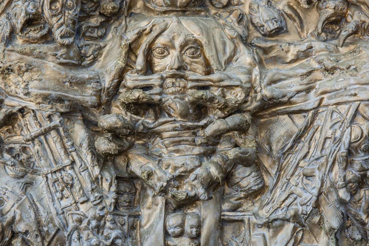 Ausschnitt aus einem Relief von Marco Kromer mit vielen Gesichtern